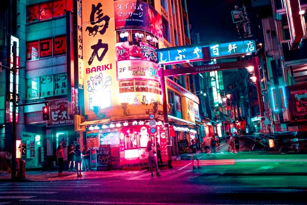 A street corner drenched in magenta and red neon signage after dark