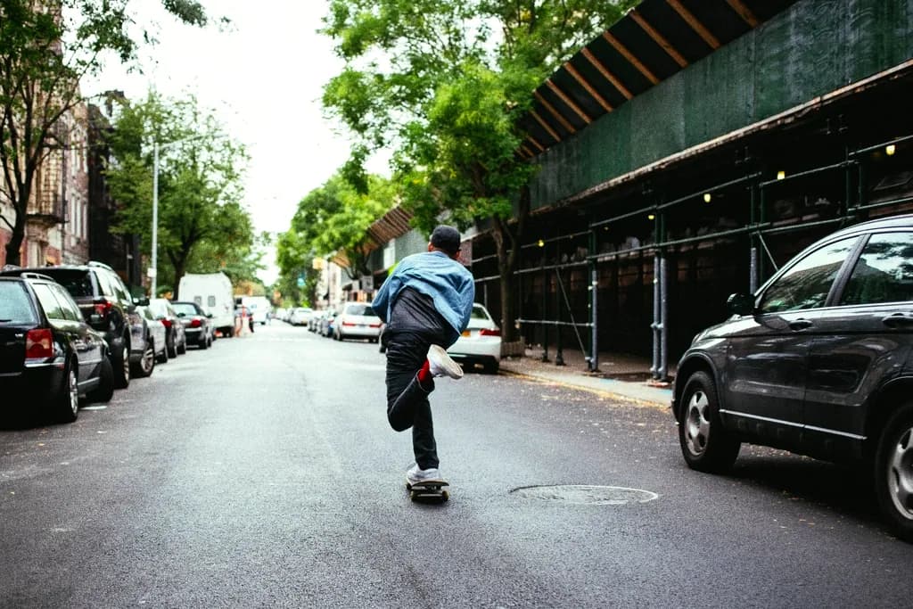 A skater pushing down the middle of a quiet residential street