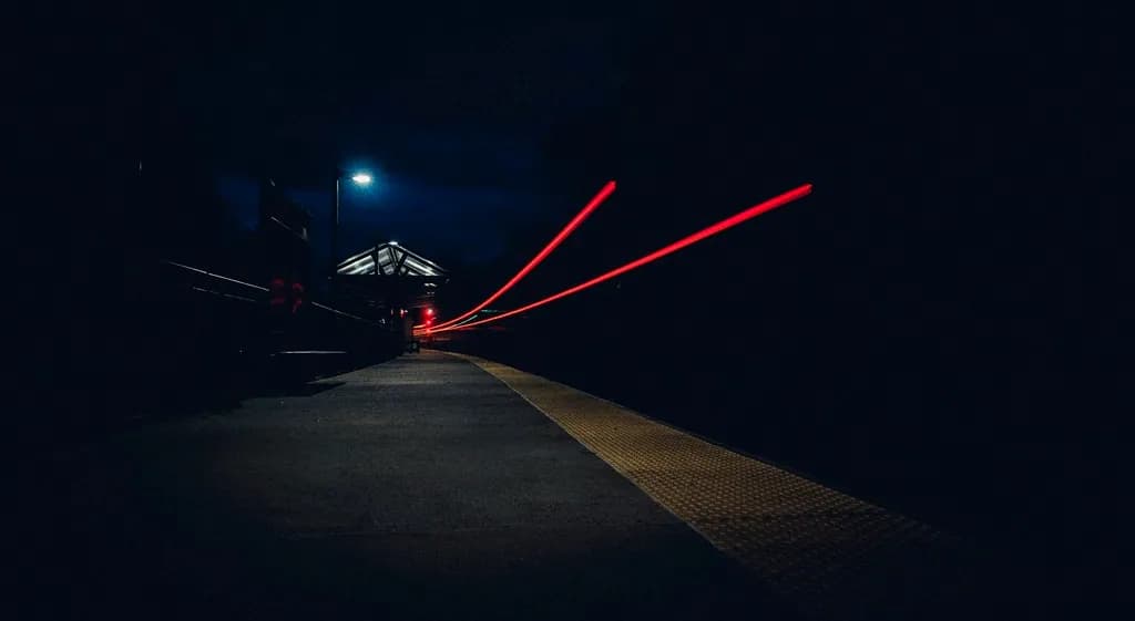 Red tail-light trails stretching down a dark road